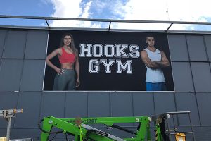 The Imagesource signage install team working at heights to install a keder edge banner and sail track billboard sign for Hooks Gym Perth